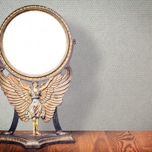 Old antique vintage cast iron desk makeup mirror frame blank holds on the stand in the form of goddess with wings or angel standing on table. Circa end of 1800s or early 1900s. Retro style filtered ; Shutterstock ID 1068945989; purchase_order: -; job: -; client: -; other: -